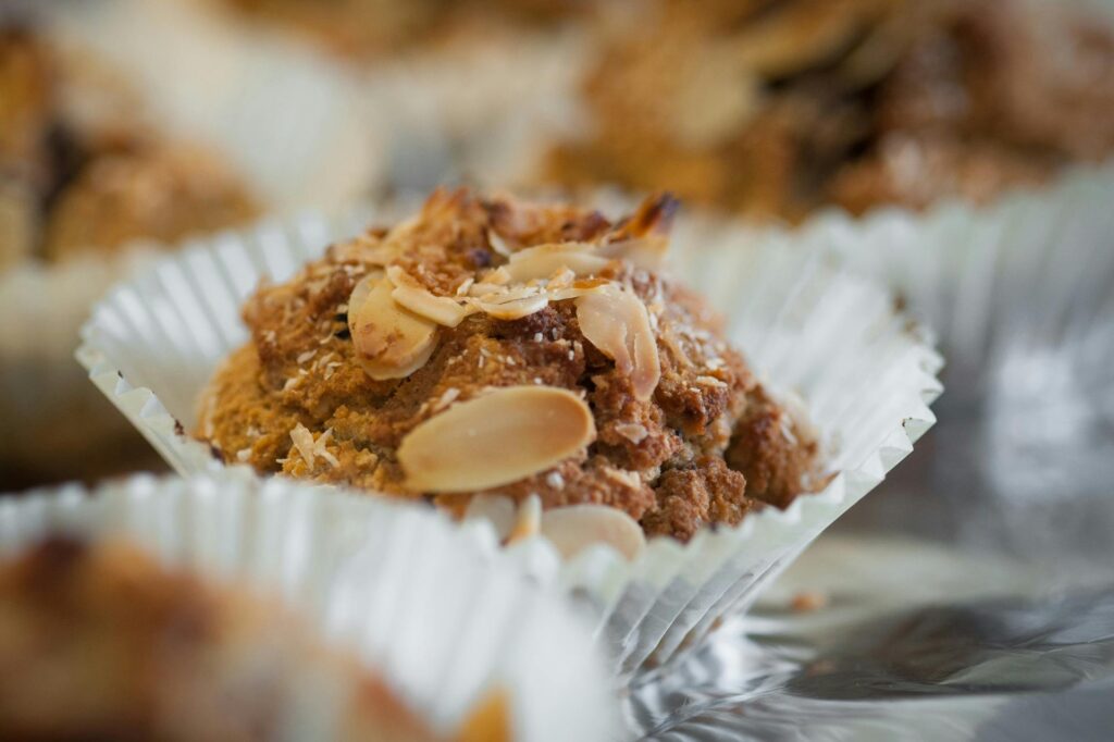 Tempting close-up shot of a tasty almond-topped muffin in a paper liner.